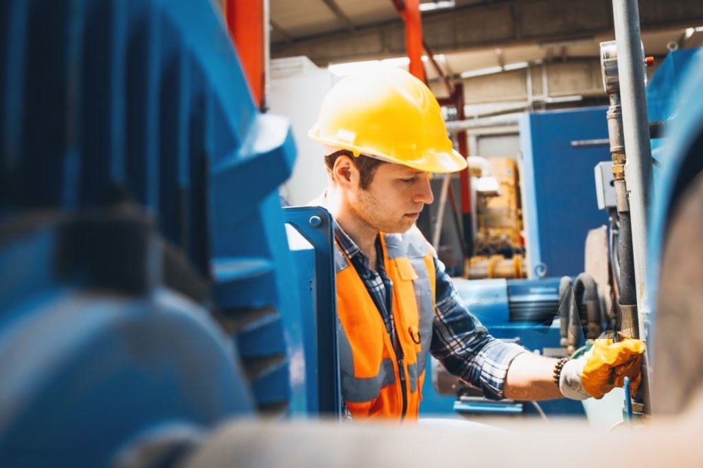 Industrial pump maintenance technician inspecting a pump